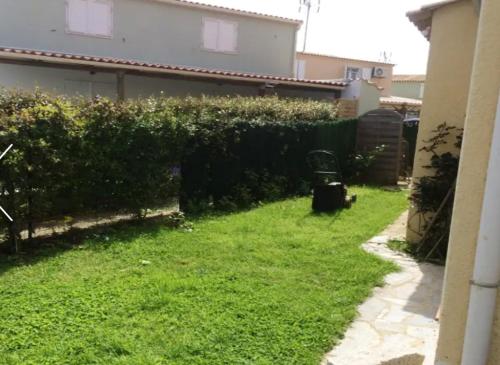a backyard with a fence and a green yard at Maison vue mer et montagne, Poggio-Mezzana in Poggio-Mezzana