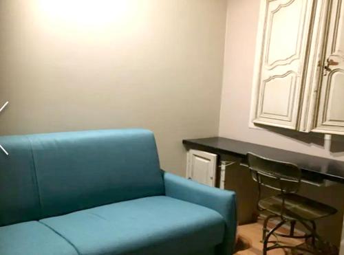 a living room with a blue couch and a counter at Maison vue mer et montagne, Poggio-Mezzana in Poggio-Mezzana