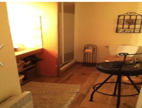 a room with a table and a stool in a room at Maison vue mer et montagne, Poggio-Mezzana in Poggio-Mezzana
