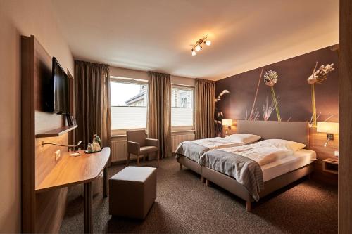 a hotel room with a bed and a desk at Landgasthaus Hotel H. Kortlüke in Belm