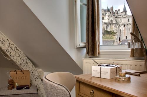 Habitación con escritorio, silla y ventana. en Le Manoir Les Minimes en Amboise