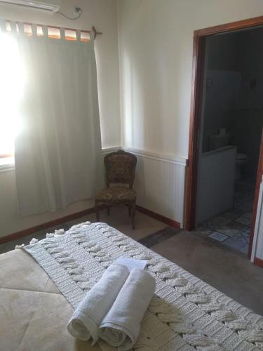 a bedroom with two towels on a bed with a chair at LOS TEROS POSADA DE CAMPO in San Rafael
