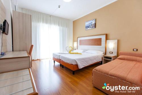 una camera d'albergo con due letti e una televisione di Hotel Castell - Montagnoli Group a Limone sul Garda