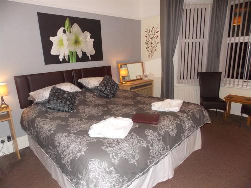 1 dormitorio con 1 cama con una pintura floral en la pared en Easton Court Guest House, en Paignton