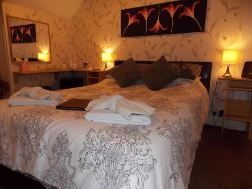 a bedroom with a bed with a laptop on it at Easton Court Guest House in Paignton