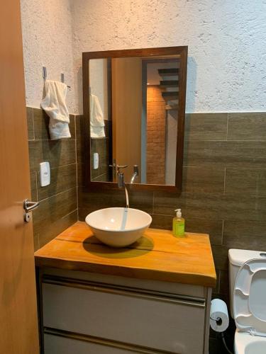 a bathroom with a bowl sink and a mirror at Vila dos Milagres Casa de Charme in São Miguel dos Milagres