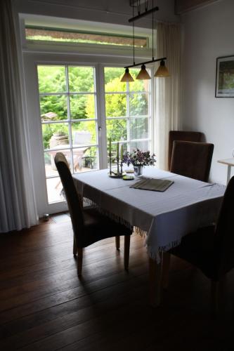a dining room table with chairs and a large window at Reethus Stöfs in Behrensdorf