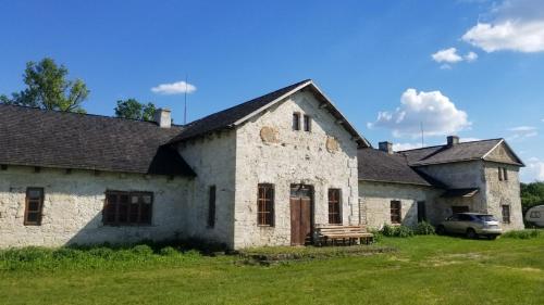 ein altes Steinhaus mit einer Bank im Hof in der Unterkunft Садиба Сцибор-Мархоцького 