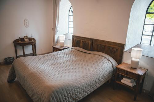 a bedroom with a bed and two tables with lamps at Sonnerupgaard Hotel & Konference in Kirke-Hvalsø
