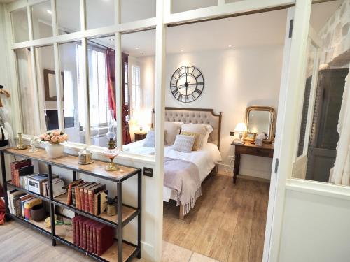 een slaapkamer met een bed en een klok aan de muur bij Le Secret - Avignon in Avignon