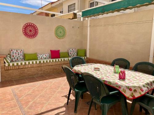 eine Terrasse mit einem Tisch, Stühlen und einer Bank in der Unterkunft Casa Valdelagrana Playa in El Puerto de Santa María