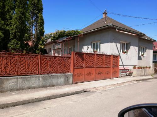 a house with a red fence on the side of a street at Kalotaszeg Vendégház in Izvoru Crişului