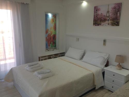 a bedroom with a bed with two towels on it at Petrakis Beach in Lefkimmi