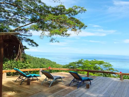 a deck with chairs and the ocean in the background at Sunset rooms - Auberge Polynésienne in Tevaitoa