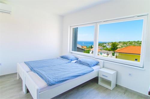um quarto com uma cama e uma grande janela em Matoc apartments em Murter
