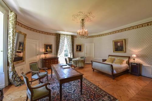 a living room with a couch and a table at La Villa Palladienne - Château de Syam in Syam
