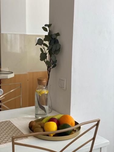 a bowl of fruit on a table with a vase at Vicky - New Apartment Centrum Srodmiescie in Warsaw