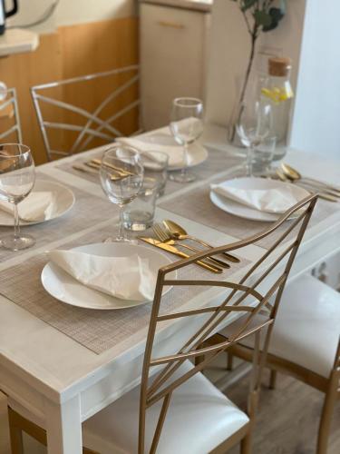 a dining room table with plates and glasses on it at Vicky - New Apartment Centrum Srodmiescie in Warsaw