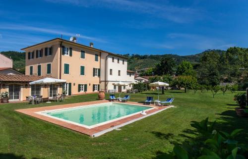 a large house with a swimming pool in the yard at Garden Relays Villa Rosy in Massarosa