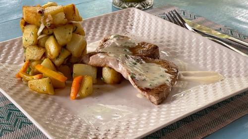 a plate of food with meat potatoes and vegetables at Atii Garden Bungalows in Nungwi