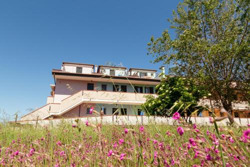 a building with a field of flowers in front of it at Appartamenti Arcobaleno in Casa Bullo