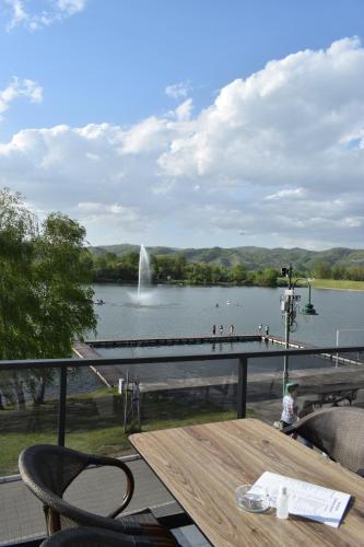 a view of a lake with a table and a fountain at Prenoćište Srebrno Jezero in Veliko Gradište