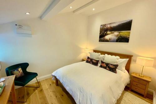 1 dormitorio con 1 cama blanca y 1 silla en Paddock View, Castle Combe, en Castle Combe