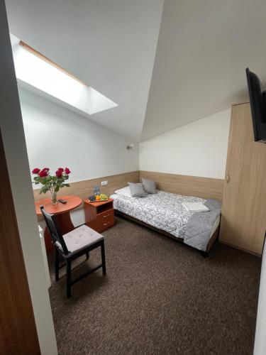 a bedroom with a bed and a desk and a table at Hotelik Gold in Raszyn