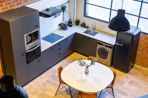 a kitchen with a table and a sink and a refrigerator at ART LOFTS Valencia by Benisur in Valencia