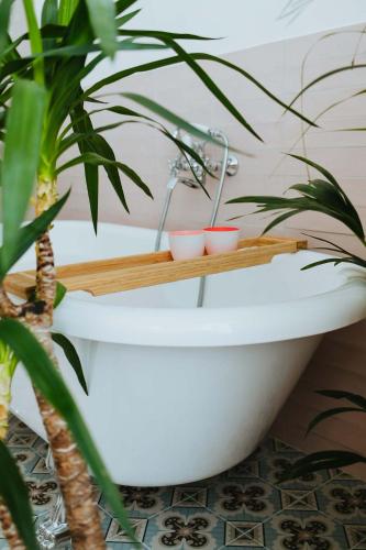 a bathroom with a white bath tub with plants at Musa Antwerp in Antwerp