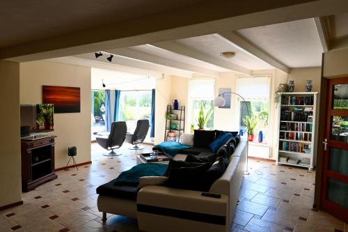 a living room with a couch and a table at Vakantiehuis het Voorhuis op Landgoed koepeltjesplaats in Gaast