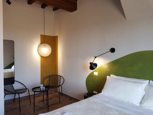 a bedroom with a bed and a table and chairs at Il Poggio di Musignano in Musignano