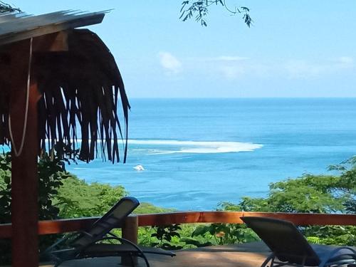 a view of the ocean from the porch of a house at Sunset rooms - Auberge Polynésienne in Tevaitoa