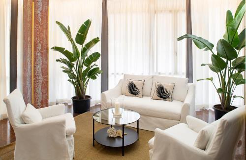 uma sala de estar com duas cadeiras brancas e uma mesa em Hotel Imperial Palace em Lido di Jesolo