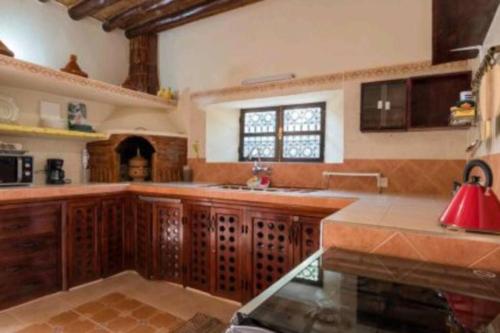 cocina grande con armarios de madera y lámpara roja en Villa privée Wafa en Marrakech