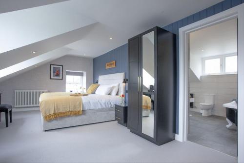 a bedroom with a large bed and a bathroom at Provident, Maritime Suites, Brixham in Brixham