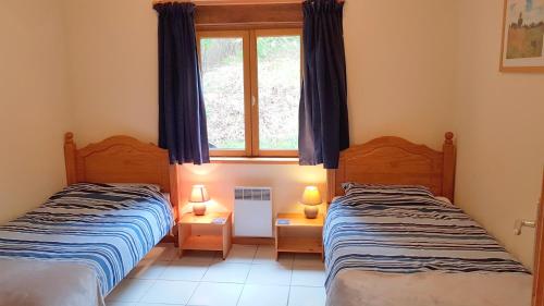 two beds in a room with a window at Exclusive countryside retreat with private lake in Montrollet