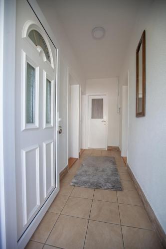 un corridoio vuoto con una porta e un pavimento piastrellato di Apartman Bokić a Trebinje