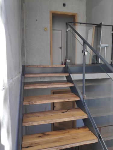 a staircase with wooden steps and a glass railing at Ferienwohnungen und Zimmer in Reutlingen-Gönningen in Reutlingen