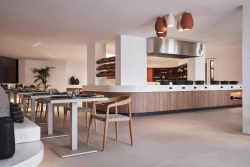 a kitchen with tables and chairs and a bar at Orama Hotel & Spa in Fira