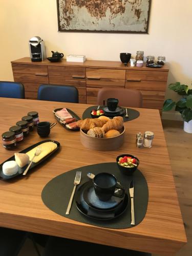 een houten tafel met een bord eten erop bij B&B Inn Between in Gent