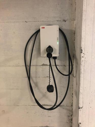 een zwarte kabel die in een licht op een muur is gestoken bij Le Vele Residence in Pietra Ligure