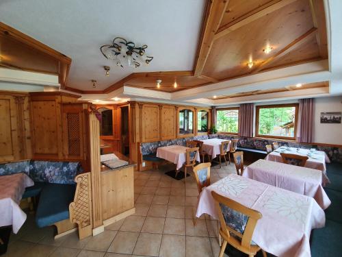 ein Restaurant mit Tischen und Stühlen in einem Zimmer in der Unterkunft Pension Tannenhof in St. Johann im Ahrntal