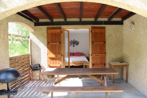 - une terrasse avec une table en bois et un lit dans l'établissement La Givrine, à Val-des-Prés
