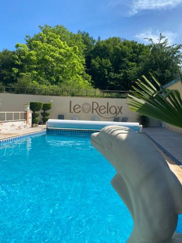 une piscine avec une statue de requin dans l'eau dans l'établissement Le Relax, à Boulazac