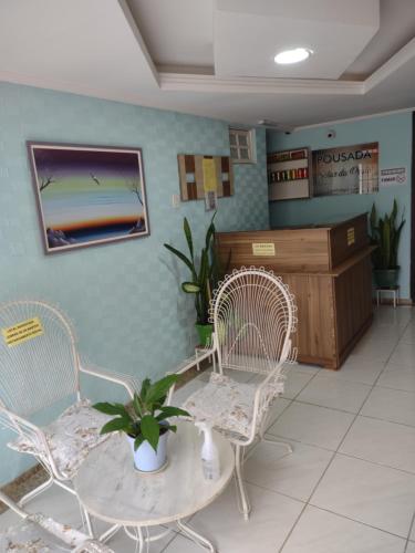 uma sala de espera com duas cadeiras e uma mesa em Pousada Solar da Praia em Guarapari