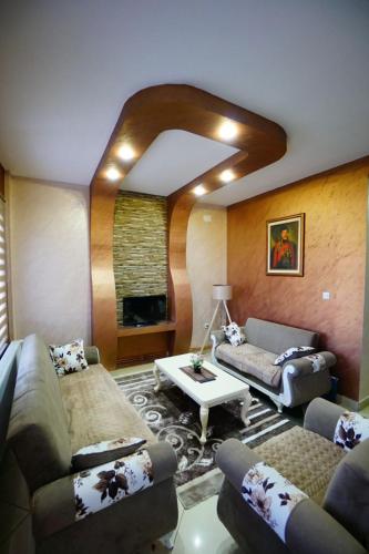 a living room with two couches and a table at Apartman Lazic in Gracanica