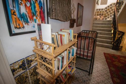 a book shelf filled with books next to a staircase at Bayt Alice Hostel in Tangier