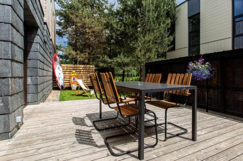a black table and chairs on a wooden deck at Don Vyto in Druskininkai