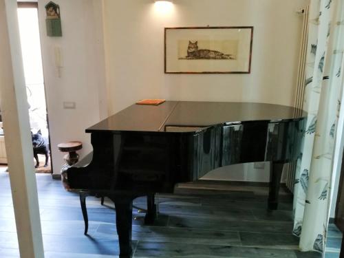 a black piano in a room with a table at Sguardo sul lago in Trevignano Romano
